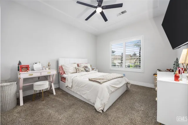 a bedroom with a bed and a flat tv screen on the dresser