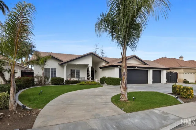 a front view of a house with a garden and trees