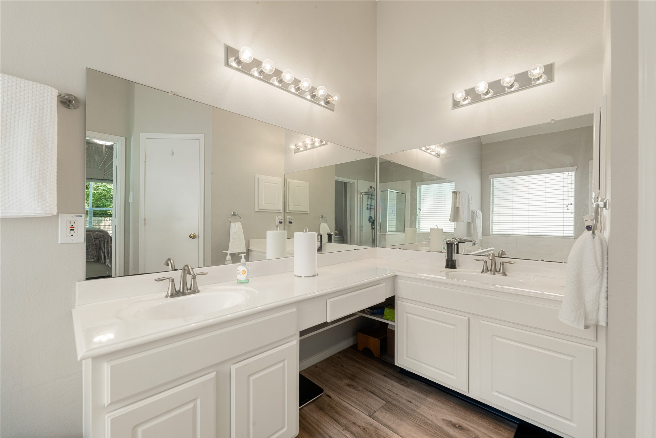 19726 Teller Boulevard Spring, TX 77388 - Photo 11 of 24 Relax and unwind in this spa-like primary bathroom, designed with both style and convenience in mind. This bright retreat features an expansive double vanity with plenty of storage, a dedicated makeup station, and clean white cabinetry. Large mirrors and bright vanity lighting enhance the airy feel, while the neutral finishes create a clean, contemporary look.