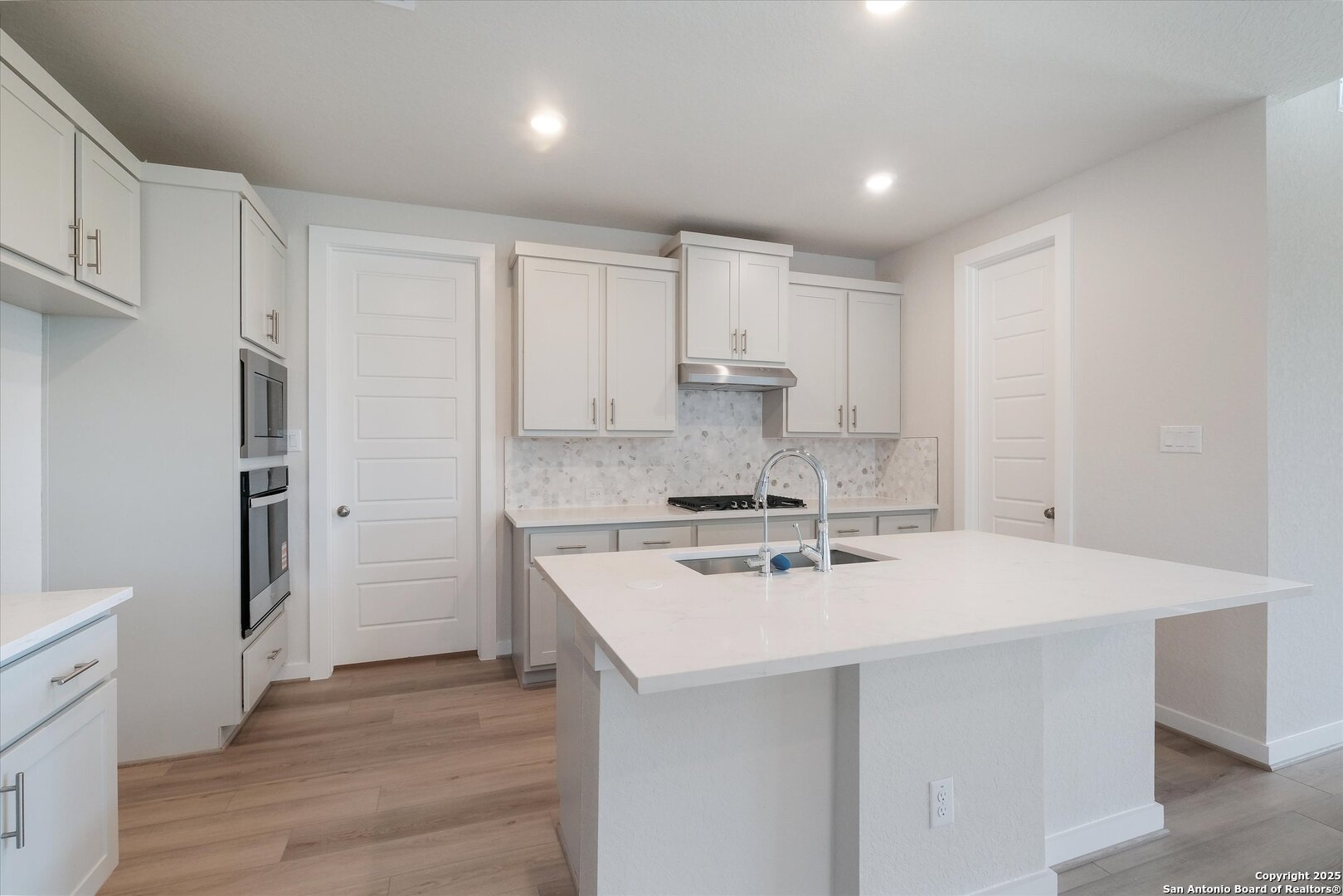 444 Foxbrook Way Cibolo, TX 78108 - Photo 4 of 17 a kitchen with a sink a stove a refrigerator and white cabinets