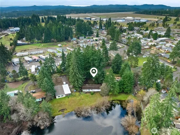 a aerial view of a house with a yard and lake view