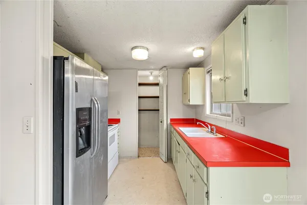 a kitchen with stainless steel appliances granite countertop a refrigerator and a sink