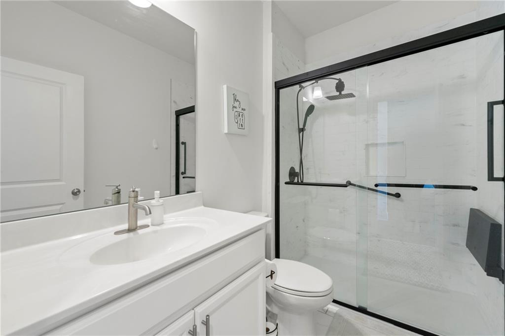 430 Plainfield Street Fayetteville, GA 30215 - Photo 17 of 21 a bathroom with a sink a toilet and a mirror