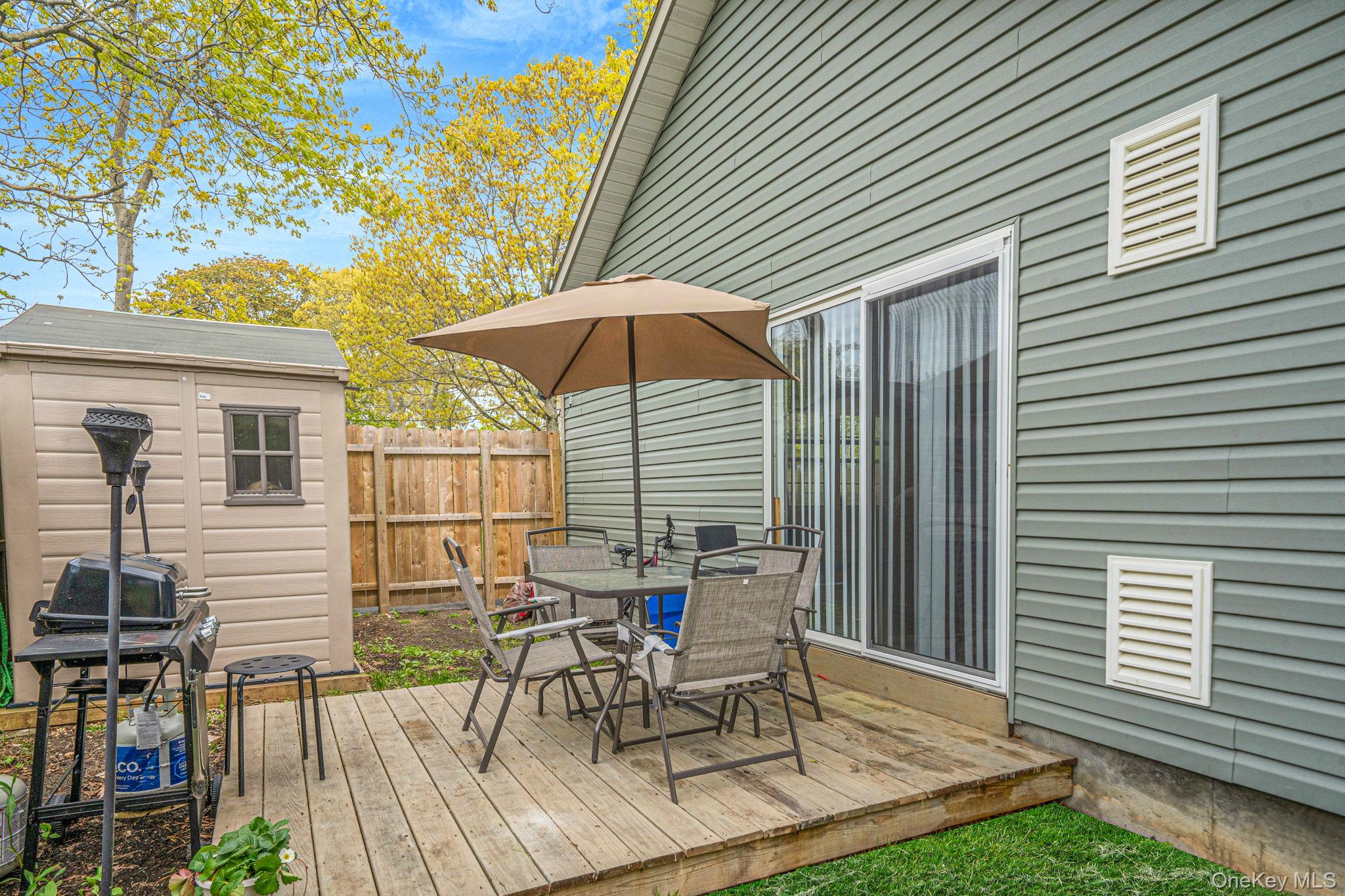 332 Commack Road Shirley, NY 11967 - Photo 21 of 25 a view of a patio with table and chairs under an umbrella