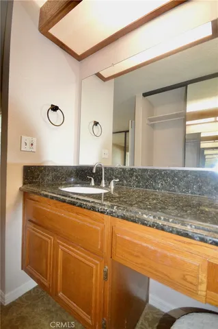 a bathroom with a granite countertop sink and a mirror