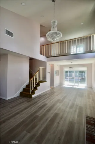 a view of an empty room with wooden floor fireplace and a window