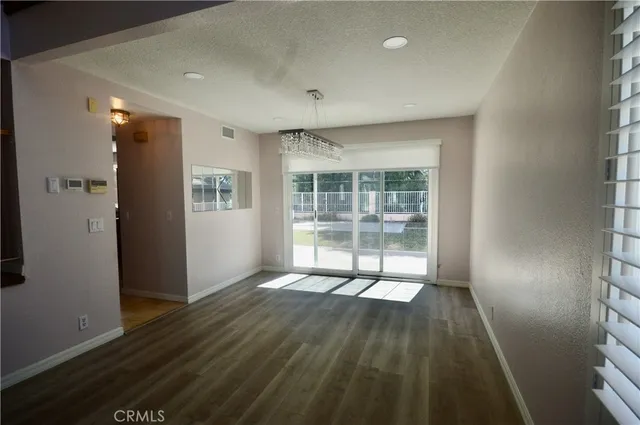 en empty room with wooden floor and windows