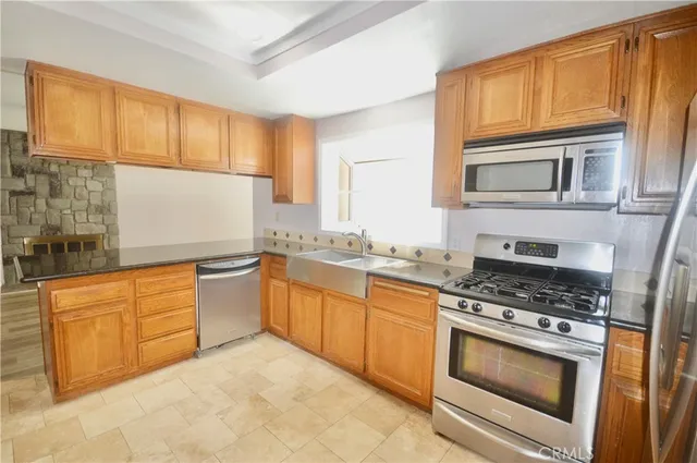 a kitchen with granite countertop a stove top oven sink and cabinets