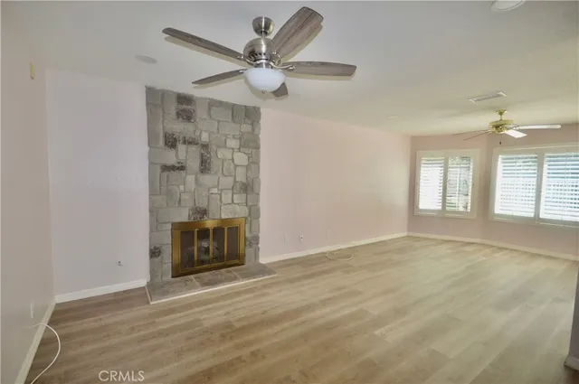 a view of an empty room with a fireplace and a window