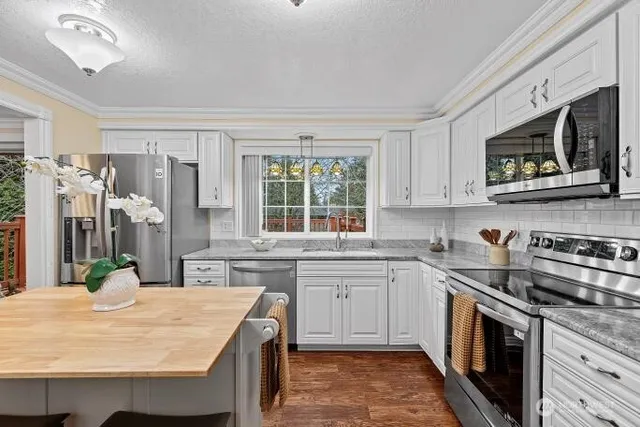 a kitchen with stainless steel appliances granite countertop a sink stove and microwave