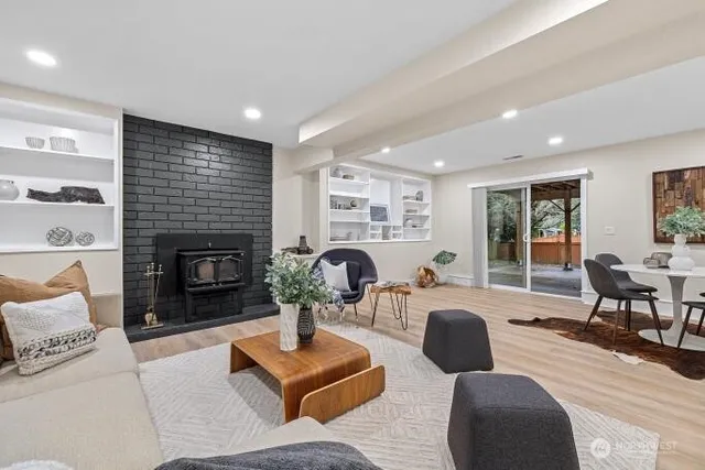 a living room with furniture a fireplace a lamp and a large window
