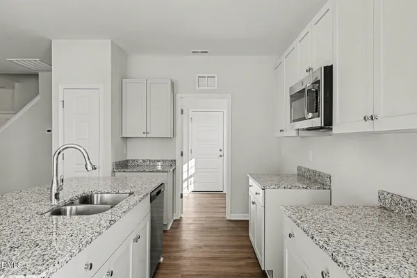 a kitchen with a sink stove and cabinets