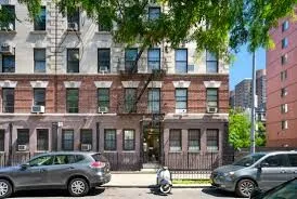 a front view of a residential apartment building with a yard