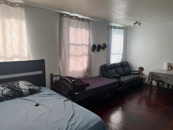 a bedroom with a bed window and couch