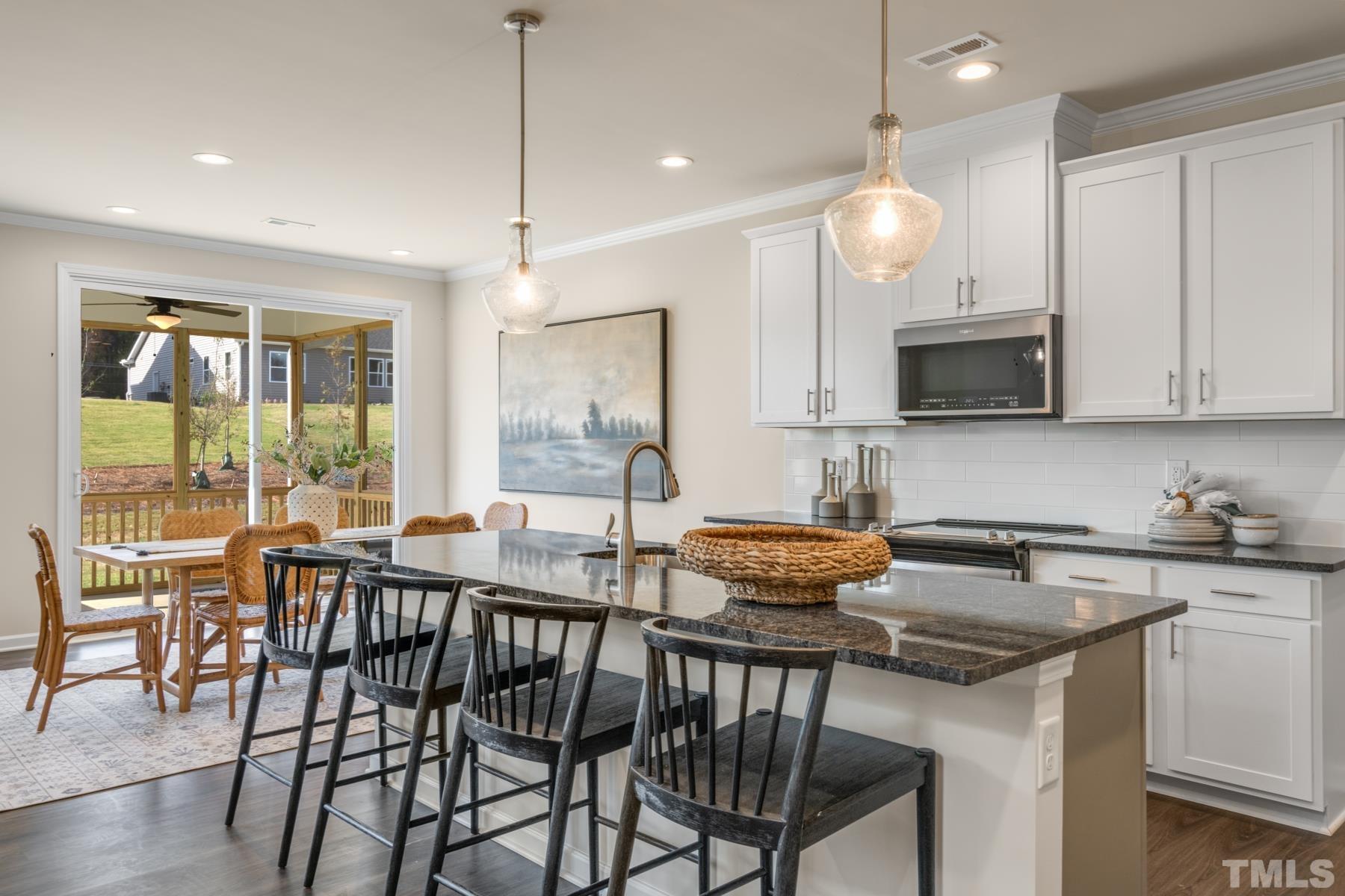 120 Yulan Way Garner, NC 27529 - Photo 15 of 30 a kitchen with a table chairs stove and cabinets