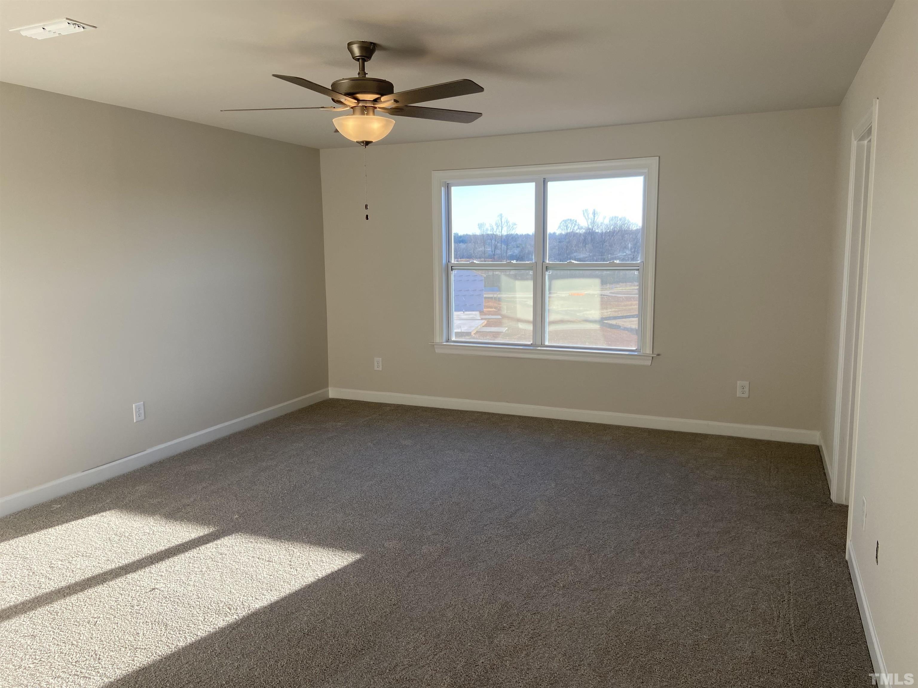 120 Yulan Way Garner, NC 27529 - Photo 9 of 30 an empty room with a window and a fan