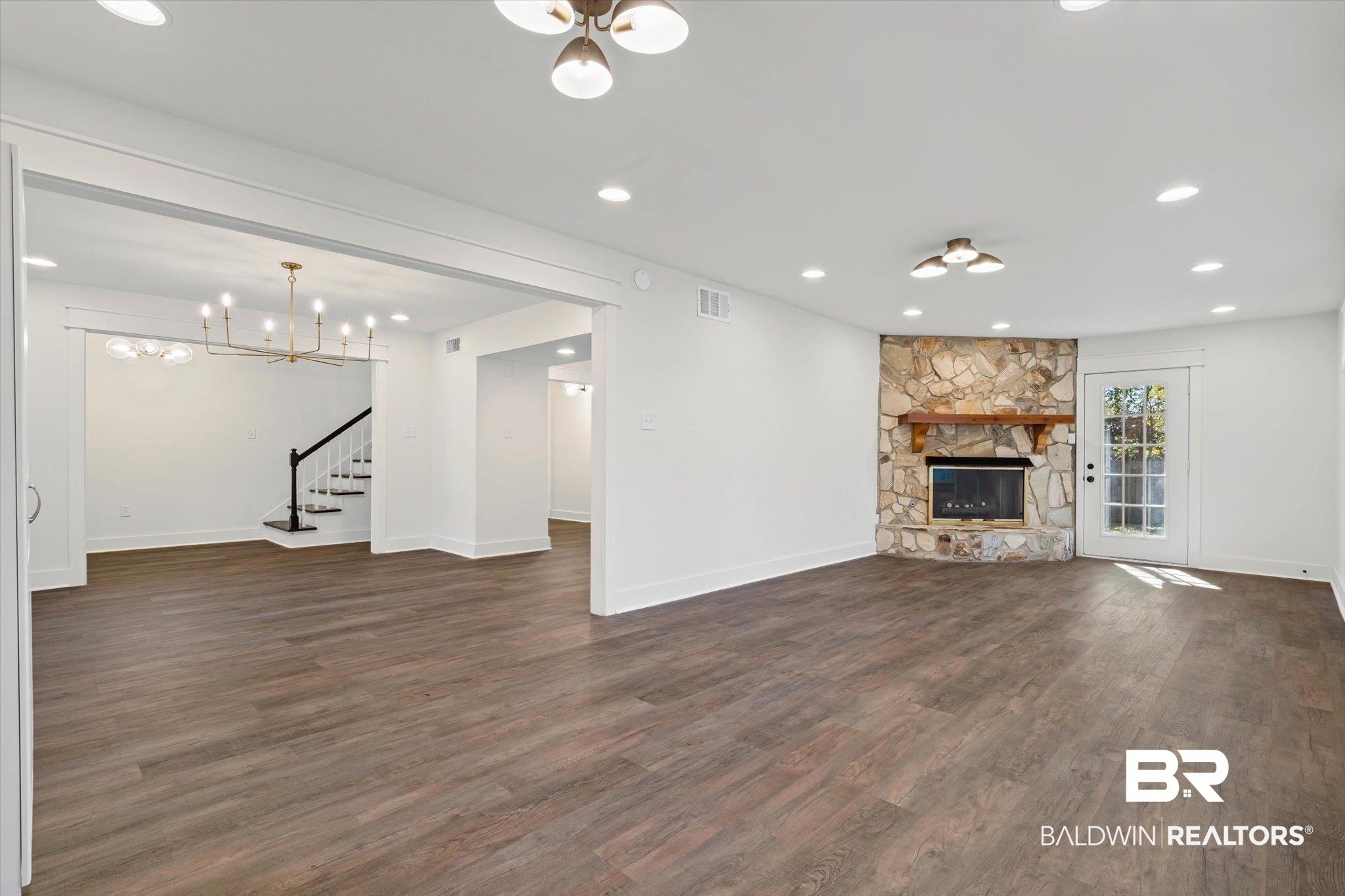 3933 Radnor Avenue Mobile, AL 36608 - Photo 7 of 36 Living or Dining room featuring a chandelier - the choice is yours ... stairs, a fireplace, recessed lighting, and dark wood-type flooring add final touches.