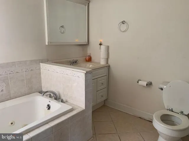 a bathroom with a granite countertop sink a toilet and bathtub