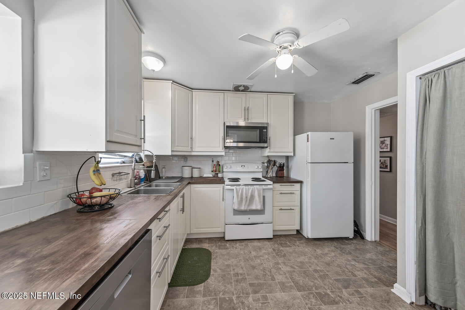 8309 Calento Street Jacksonville, FL 32211 - Photo 12 of 22 a kitchen with white cabinets and white appliances