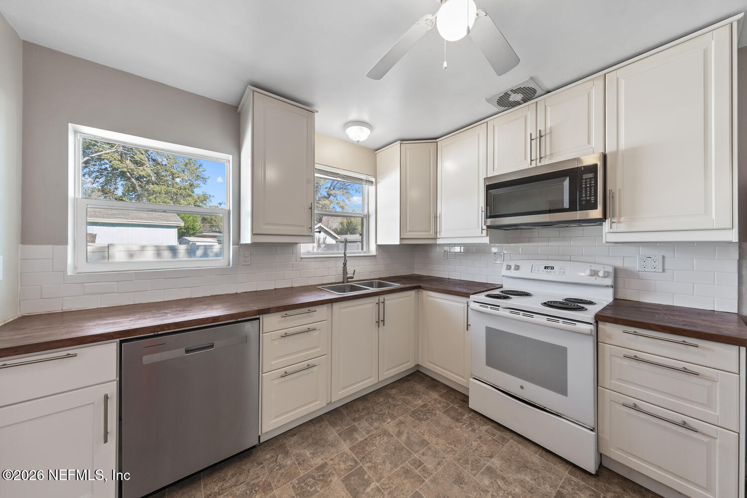 8309 Calento Street Jacksonville, FL 32211 - Photo 14 of 25 a kitchen with stainless steel appliances granite countertop white cabinets a sink and a window
