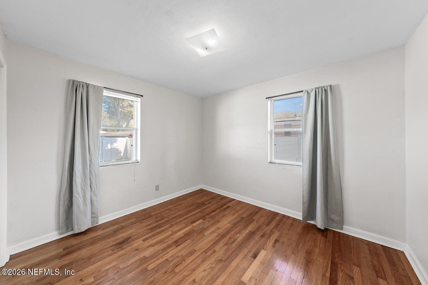 8309 Calento Street Jacksonville, FL 32211 - Photo 19 of 25 an empty room with wooden floor and windows
