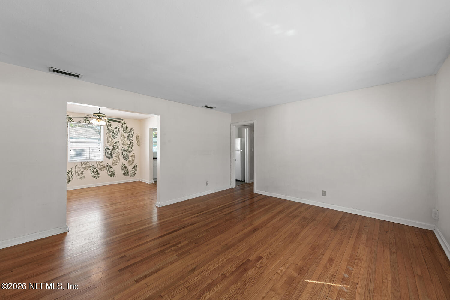 8309 Calento Street Jacksonville, FL 32211 - Photo 8 of 25 an empty room with wooden floor and windows