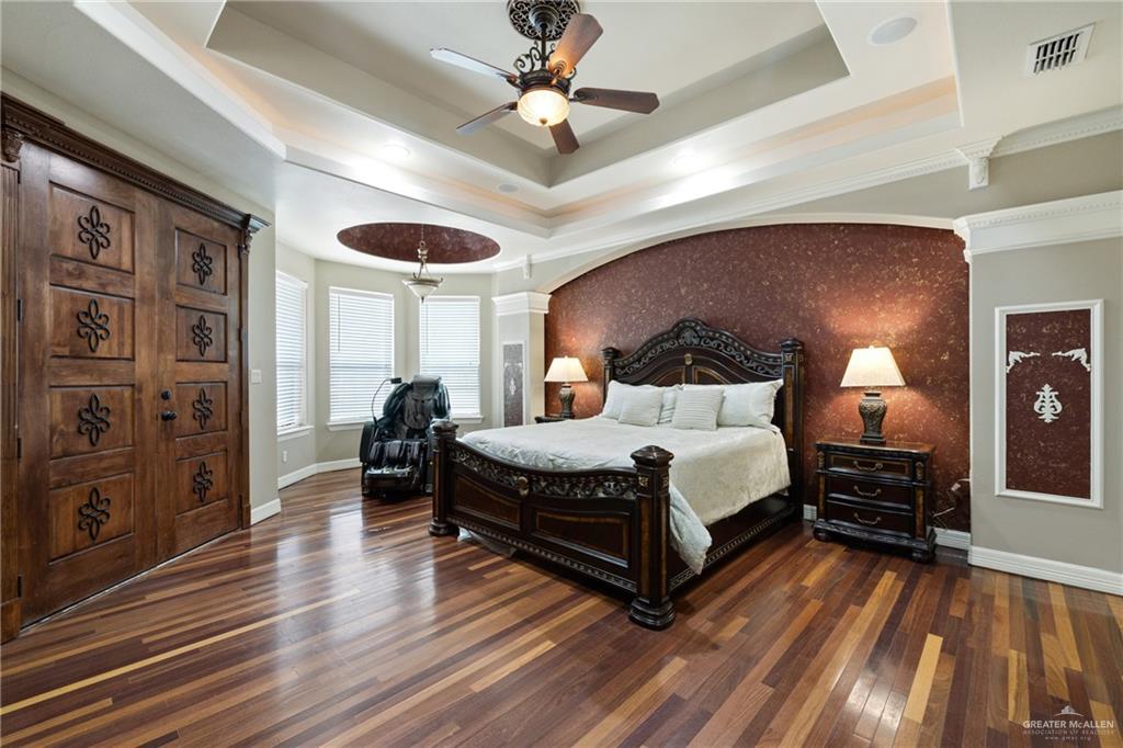 22209 Uresti Road Edinburg, TX 78542 - Photo 11 of 38 a spacious bedroom with a bed and a chandelier