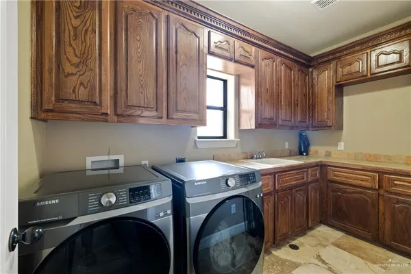 a utility room with sink dryer and washer