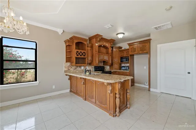 a large kitchen with stainless steel appliances granite countertop a stove and a sink