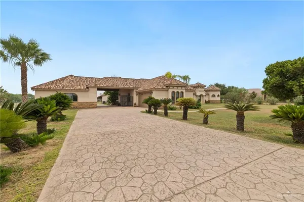 a view of a white house with a yard and potted plants