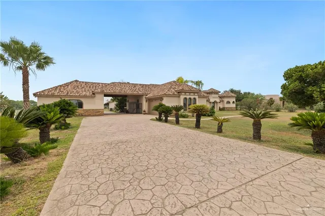 a view of a white house with a yard and potted plants