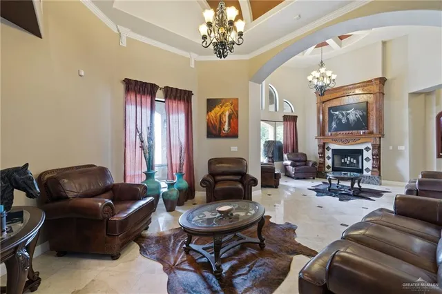 a living room with furniture a fireplace and a chandelier