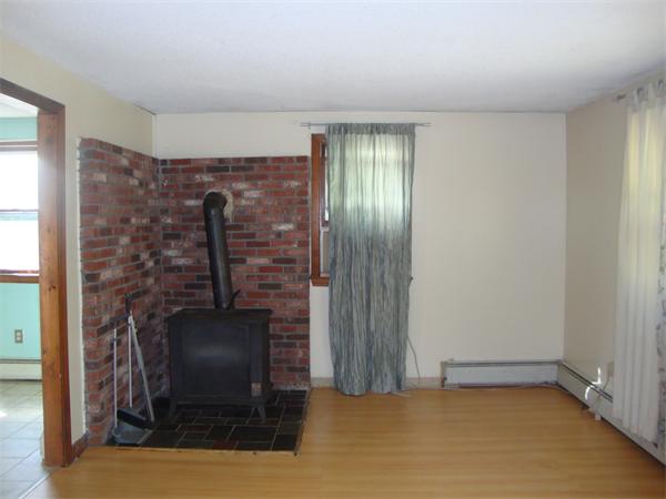 118 High Street Rochester, MA 02770 - Photo 4 of 13 a view of an empty room with a fireplace and a window