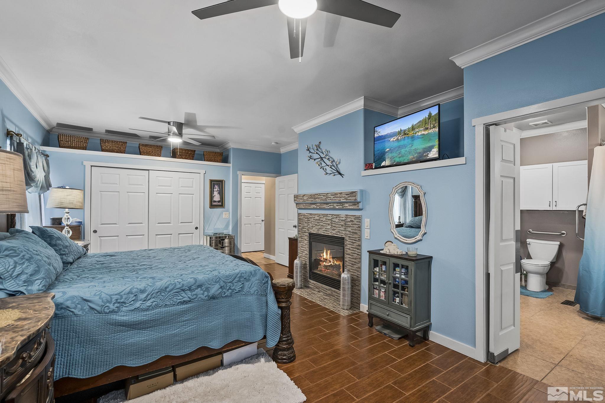 7615 Crest Bluff Drive Reno, NV 89506 - Photo 12 of 32 a bedroom with a bed a fireplace and a flat screen tv