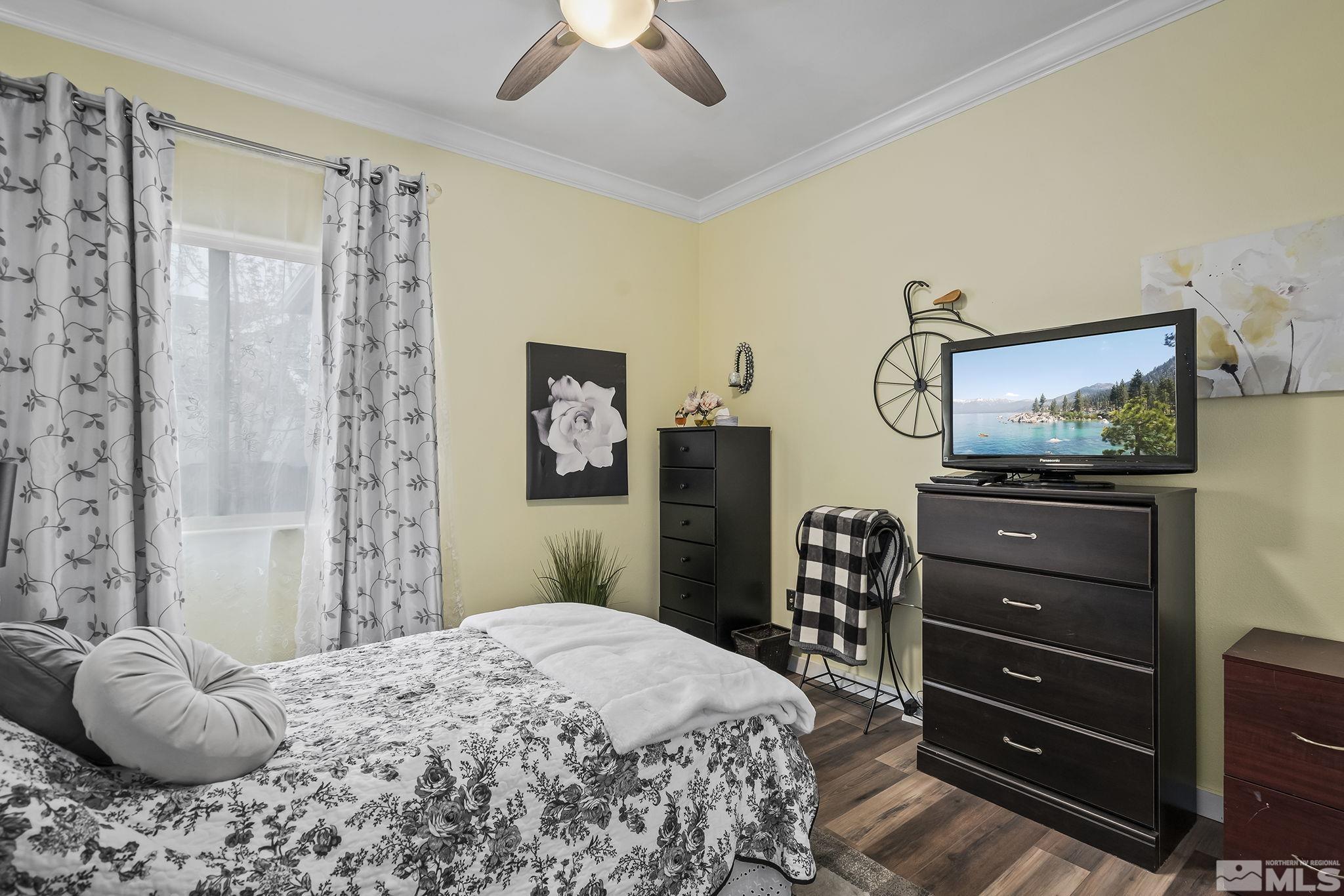 7615 Crest Bluff Drive Reno, NV 89506 - Photo 21 of 32 a bedroom with a bed and a flat tv screen on dresser