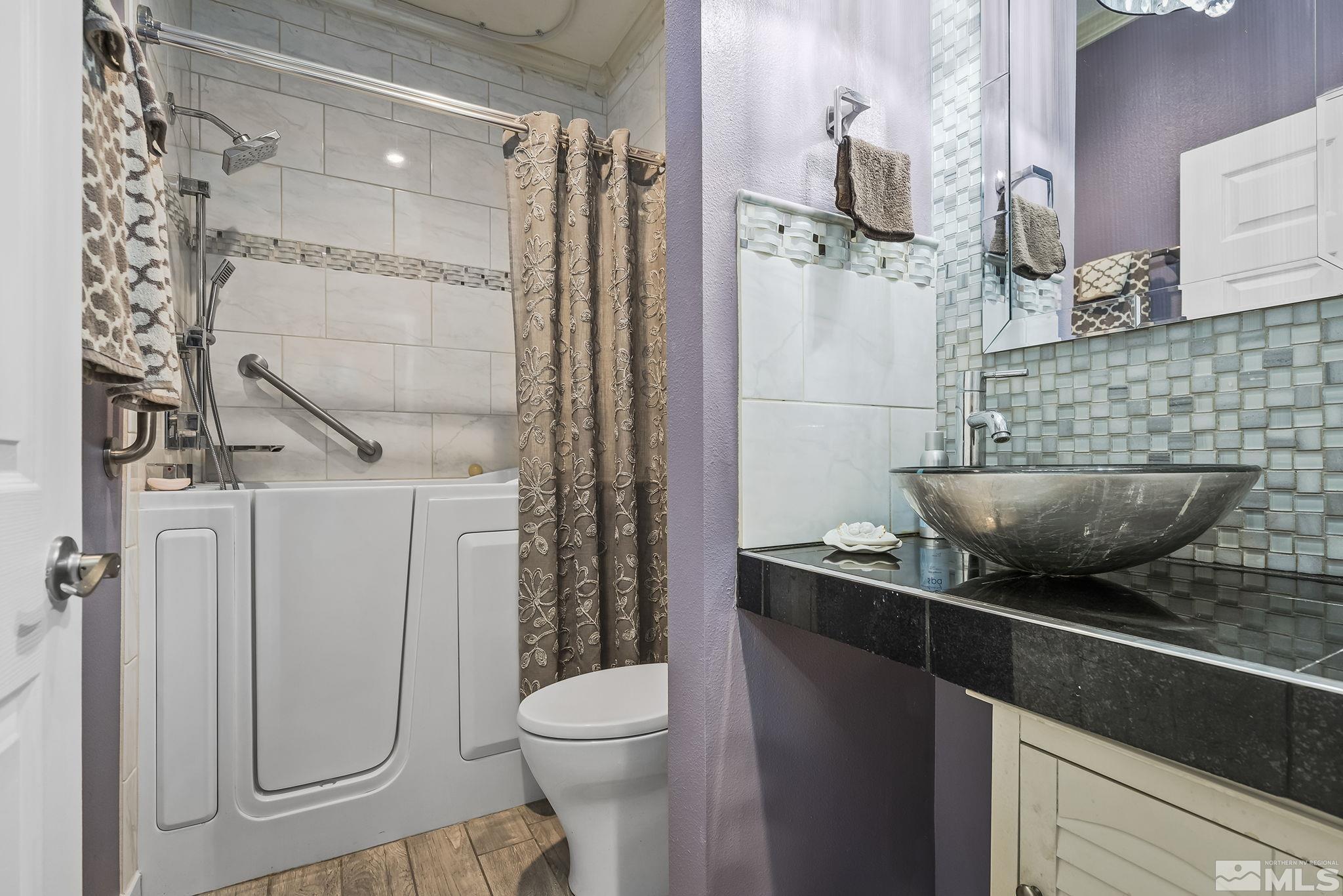 7615 Crest Bluff Drive Reno, NV 89506 - Photo 22 of 32 a bathroom with a granite countertop sink a toilet and shower