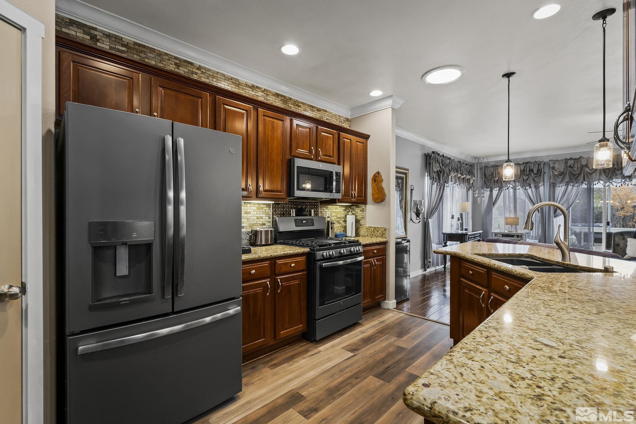 7615 Crest Bluff Drive Reno, NV 89506 - Photo 10 of 32 a kitchen with stainless steel appliances granite countertop a refrigerator stove and sink