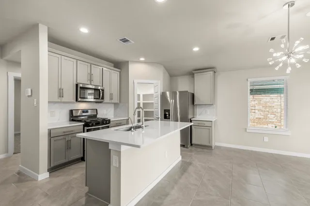 a kitchen with stainless steel appliances a refrigerator sink and stove