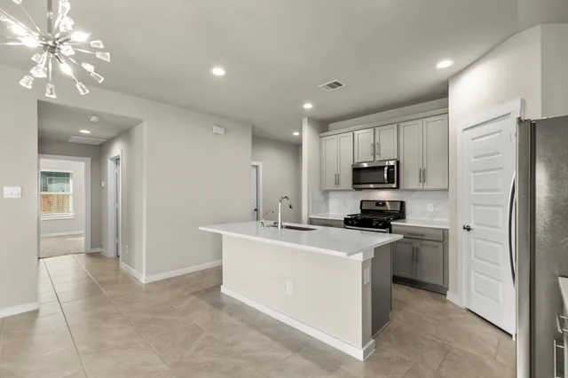a kitchen with kitchen island a sink stainless steel appliances and cabinets