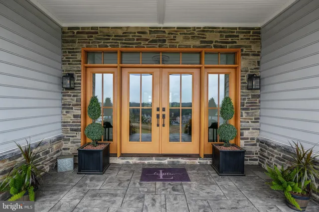 a large kitchen with stainless steel appliances kitchen island granite countertop a table chairs and a refrigerator