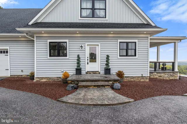 a living room with furniture dining table a fireplace and a large window