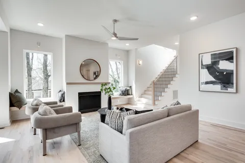 a living room with furniture a fireplace and a large window