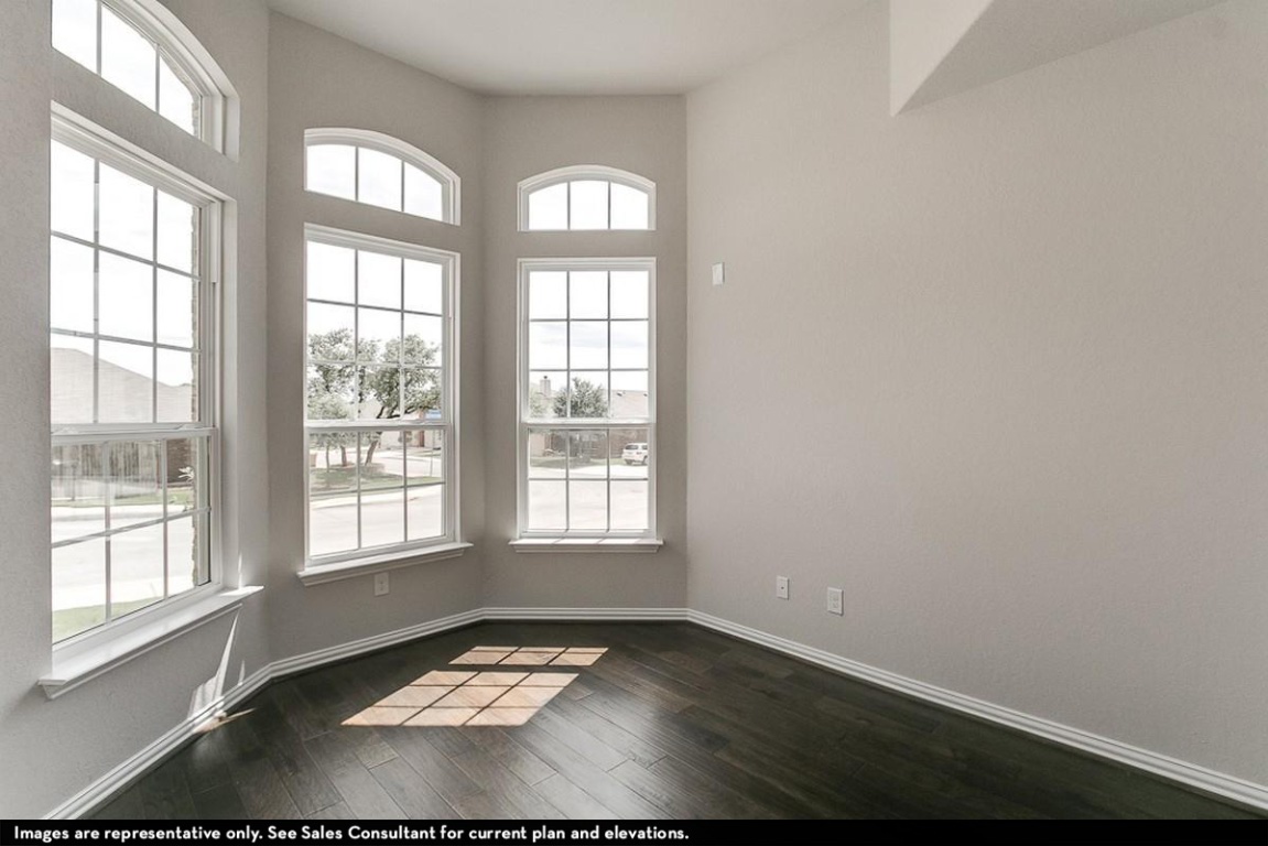 265 Rubber Tree Way Buda, TX 78610 - Photo 2 of 11 an empty room with wooden floor and windows