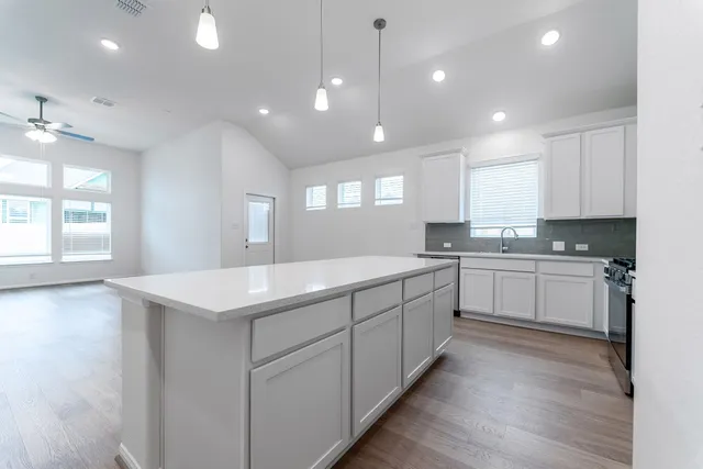 a kitchen with a sink window and cabinets
