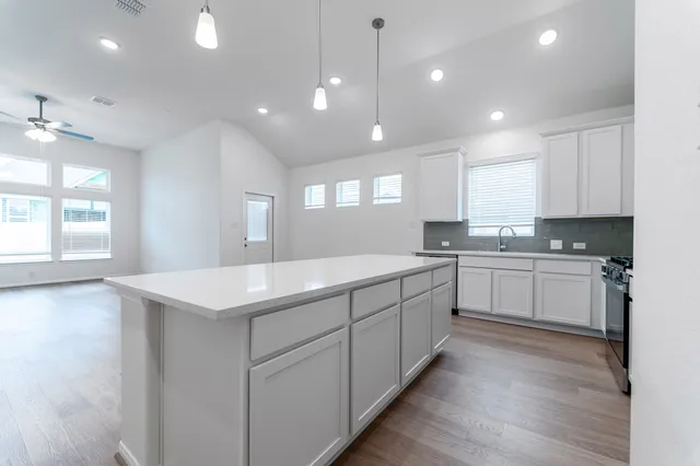 a kitchen with a sink window and cabinets