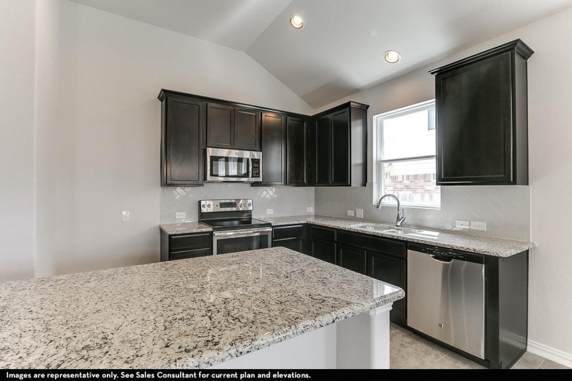 265 Rubber Tree Way Buda, TX 78610 - Photo 7 of 11 a kitchen with a sink stove and refrigerator
