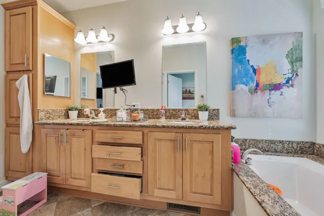 a bathroom with a granite countertop sink a toilet and a mirror