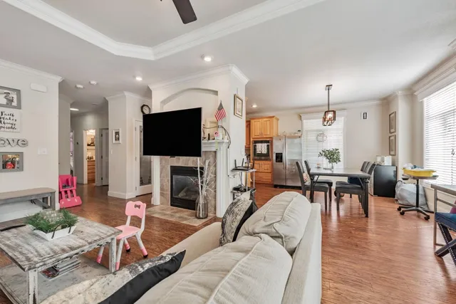 a living room with furniture flat screen tv and wooden floor