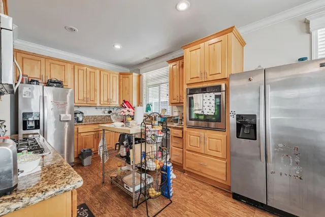 a kitchen with stainless steel appliances granite countertop a refrigerator and a stove top oven