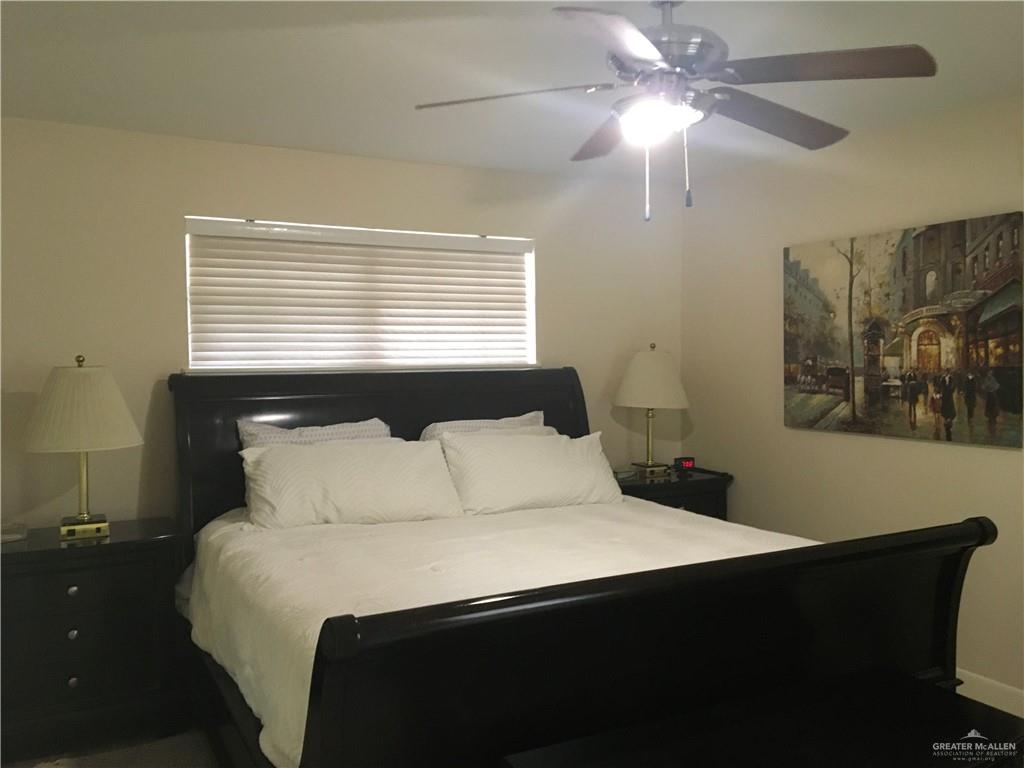 700 Fern Street, Unit 5 McAllen, TX 78504 - Photo 13 of 22 a bedroom with a bed and a chandelier